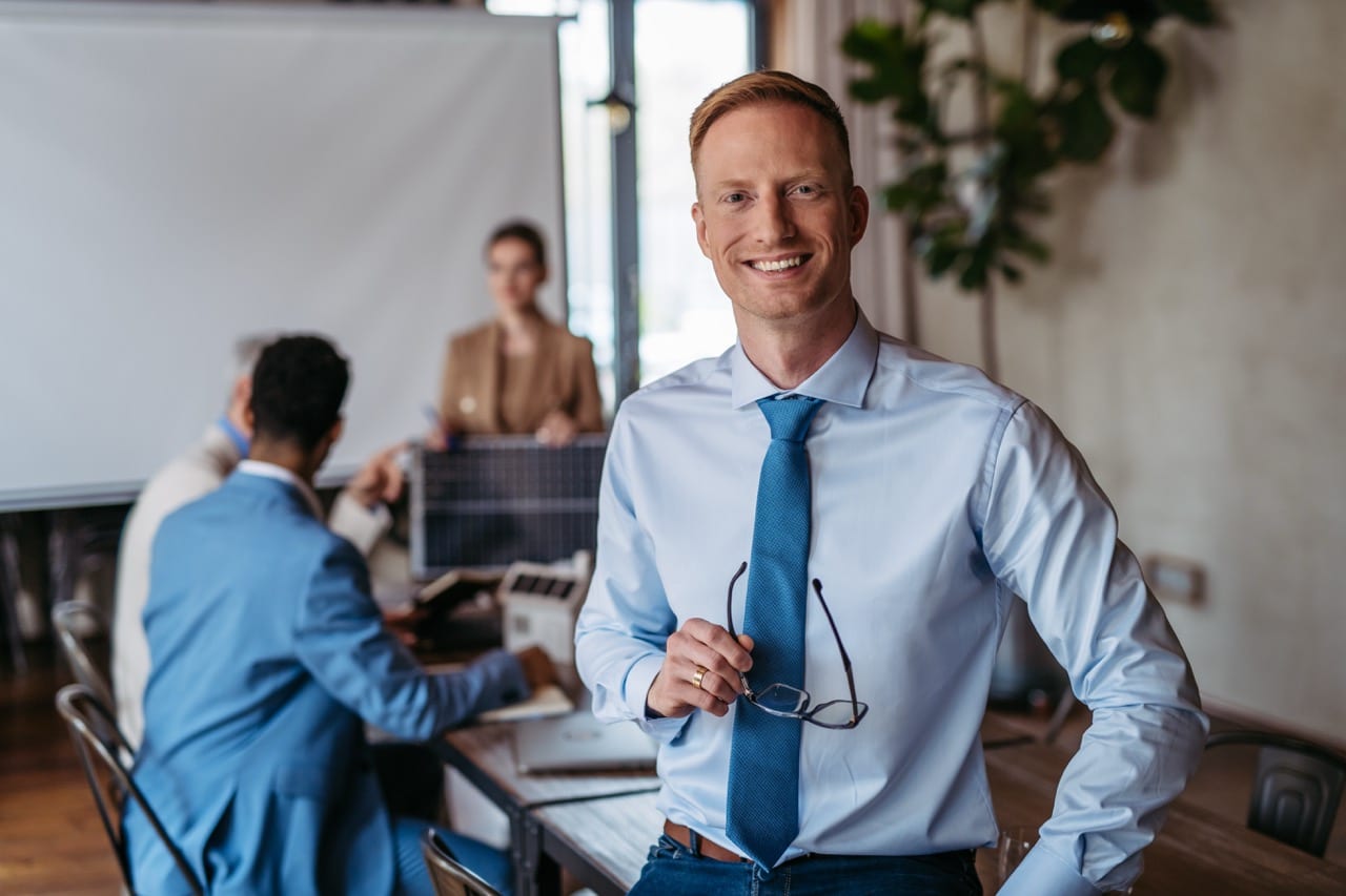 man holding glasses in an office