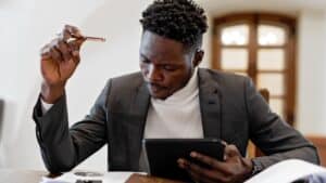 Focused professional reviewing data charts in a bright office setting, demonstrating the detail-oriented work and dynamic environment of those who explore why work in the finance industry.