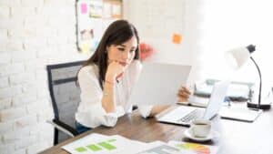 Finance professional calculating figures and reviewing reports, representing the analytical challenges and impactful decision-making behind the question of why work in the finance industry.